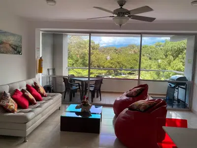 a living room with a couch and a large window at Apartamento en Condominio in San Jerónimo