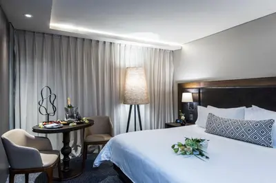 a hotel room with a bed and a table with chairs at Movich Hotel Las Lomas in Rionegro