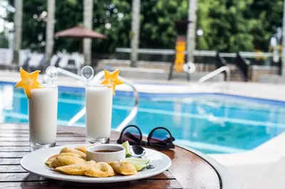 a plate of food on a table next to a pool at Movich Hotel Las Lomas in Rionegro