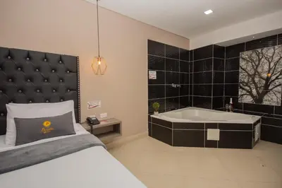 a bedroom with a bed and a bath tub at Hotel Perlatto in Bello