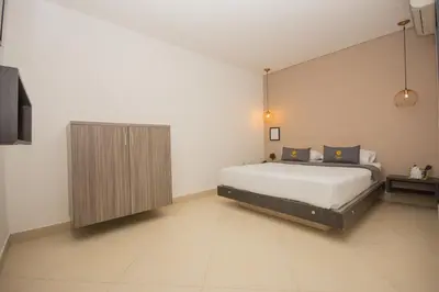 a bedroom with a bed and a wooden cabinet at Hotel Perlatto in Bello