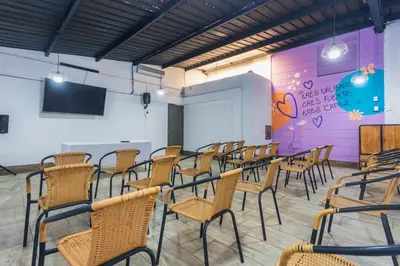 a room with a bunch of chairs and a projection screen at Hotel Perlatto in Bello