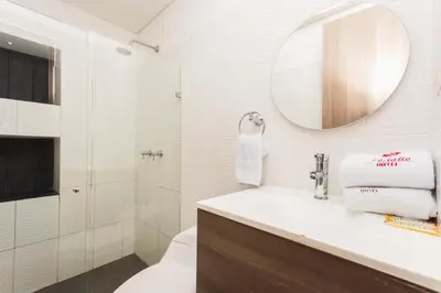 a bathroom with a sink and a mirror and a toilet at Hotel Perlatto in Bello