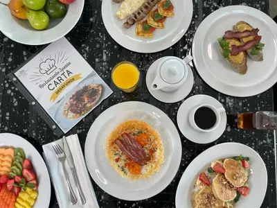 a table topped with plates of food and drinks at Hotel San Fernando Plaza in Medellín