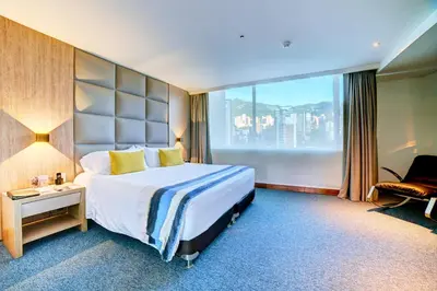 a hotel room with a bed and a large window at Hotel San Fernando Plaza in Medellín