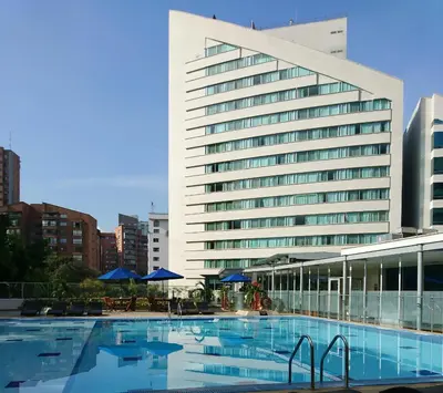a large building with a swimming pool in front of it at Hotel San Fernando Plaza in Medellín