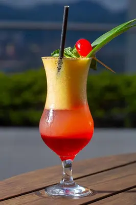 a drink in a glass with a cherry on a table at Hotel San Fernando Plaza in Medellín