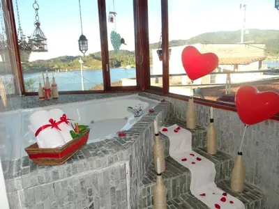 a bathroom with a bath tub with two hearts balloons at Hotel Guatatur in Guatapé