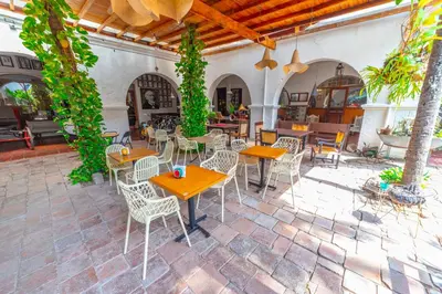 an outdoor patio with tables and chairs and plants at Hotel Mariscal Robledo in Santa Fe de Antioquia