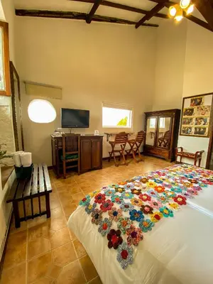 a bedroom with a large bed with flowers on it at Hotel Mariscal Robledo in Santa Fe de Antioquia