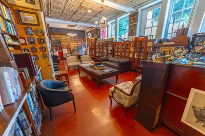 a library filled with lots of furniture and books at Hotel Mariscal Robledo in Santa Fe de Antioquia
