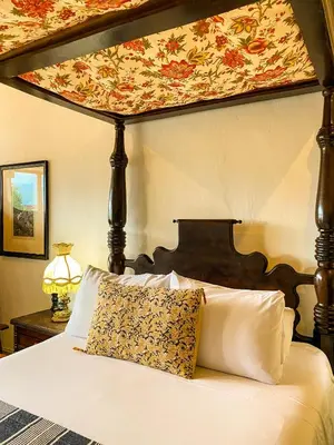a bedroom with a canopy bed with white pillows at Hotel Mariscal Robledo in Santa Fe de Antioquia