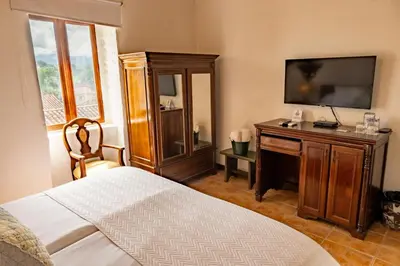 a bedroom with a bed and a flat screen tv at Hotel Mariscal Robledo in Santa Fe de Antioquia
