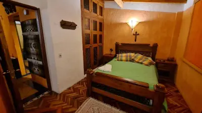 a small bedroom with a bed and a cross on the wall at Apartamento Acogedor en el Retiro in El Retiro