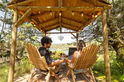 a man and woman sitting in chairs under a pergola at Levit Glamping - Hotel Guatapé Peñol in Guatapé
