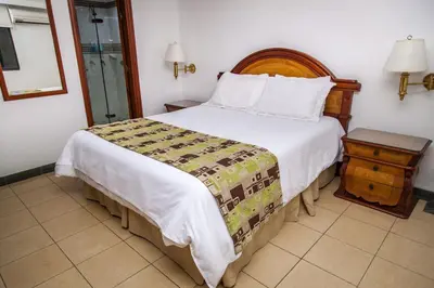 a bedroom with a large bed with a wooden headboard at Hotel Casa Laureles in Medellín