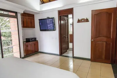 a bedroom with a bed and a tv on a wall at Hotel Casa Laureles in Medellín