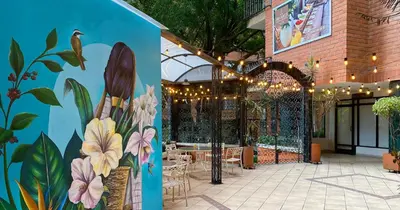 a mural on the side of a building with a patio at Hotel Casa Laureles in Medellín
