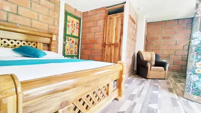 a bedroom with a wooden bed and a chair at Hostal Vista Hermosa in San Rafael