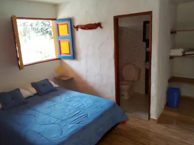 a bedroom with a blue bed and a window at Hostal Encanto La Salada in Jardin