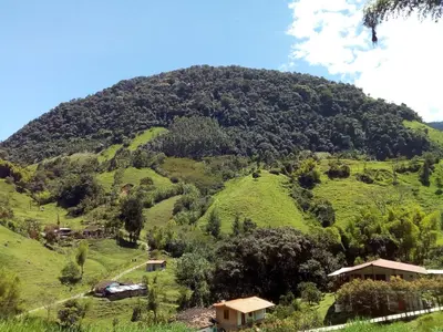 a large green hill with houses on it at Hostal Encanto La Salada in Jardin