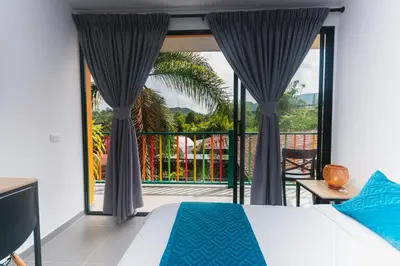 a bedroom with a bed and a large window at Guatapé Country House Hotel in Guatapé