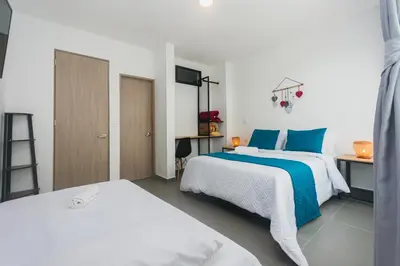 a bedroom with two beds with blue and white sheets at Guatapé Country House Hotel in Guatapé