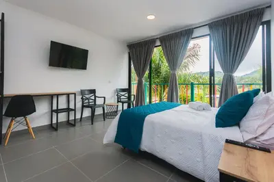 a bedroom with a bed and a balcony at Guatapé Country House Hotel in Guatapé