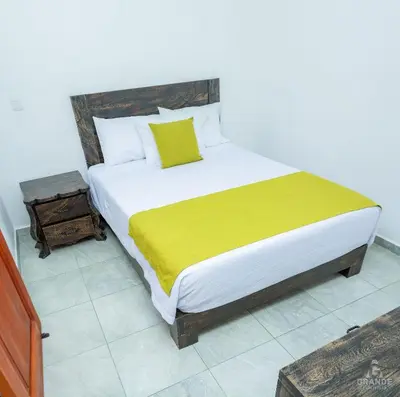 a bedroom with a large bed with a yellow blanket at Hotel Madre Laura Jericó in Jericó
