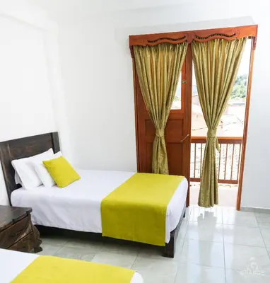 a bedroom with two beds and a window at Hotel Madre Laura Jericó in Jericó