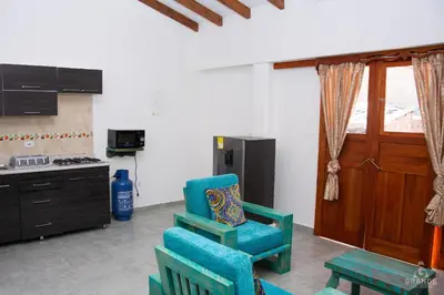 a kitchen with two chairs and a table and a stove at Hotel Madre Laura Jericó in Jericó