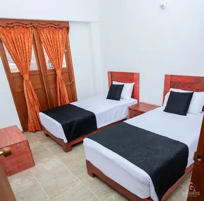 a bedroom with two beds and a window at Hotel Madre Laura Jericó in Jericó