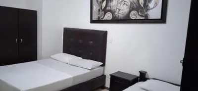 a bedroom with a bed with a black headboard at Hotel Recuerdos del Estadio in Medellín