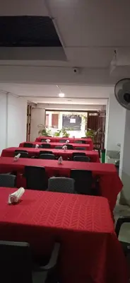 a row of red tables and chairs in a room at Hotel Recuerdos del Estadio in Medellín
