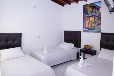a room with two beds and two swans in it at Hotel Recuerdos del Estadio in Medellín