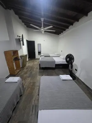 a room with two beds and a ceiling fan at Hotel Prestige in Medellín