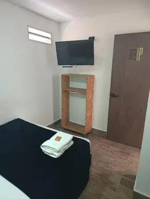 a bedroom with a bed with a tv on the wall at Hotel Prestige in Medellín