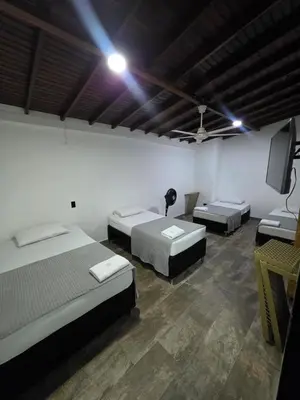 a room with three beds and a flat screen tv at Hotel Prestige in Medellín