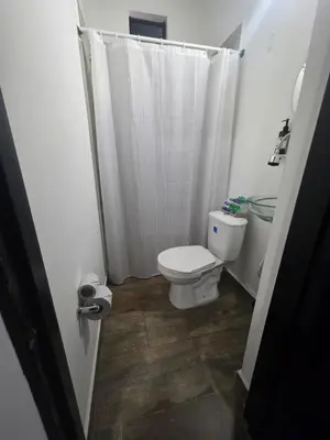 a bathroom with a toilet and a shower curtain at Hotel Prestige in Medellín