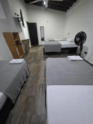 a room with three beds in a room at Hotel Prestige in Medellín