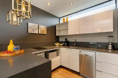 a kitchen with white cabinets and a counter top at Loma Verde Aparthotel in Medellín