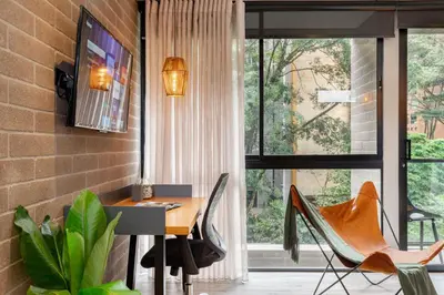 a dining room with a table and chairs and a window at Loma Verde Aparthotel in Medellín