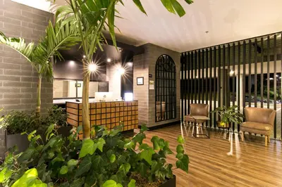 a lobby with chairs and plants in a building at Loma Verde Aparthotel in Medellín