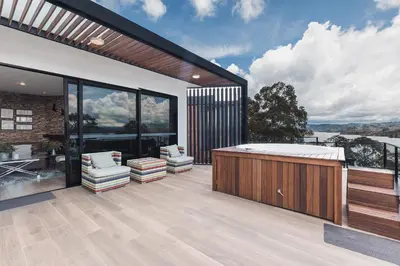 a bathroom with a hot tub and a deck with a hot tub at Luxé Cabañas in Guatapé