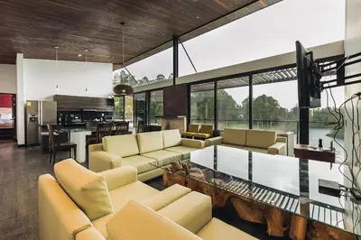 a living room with yellow furniture and a glass table at Luxé Cabañas in Guatapé