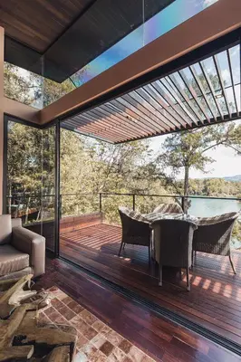 a large deck with a table and chairs on it at Luxé Cabañas in Guatapé