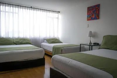 a room with two beds and a window at Hotel Portal de Milán in Manizales