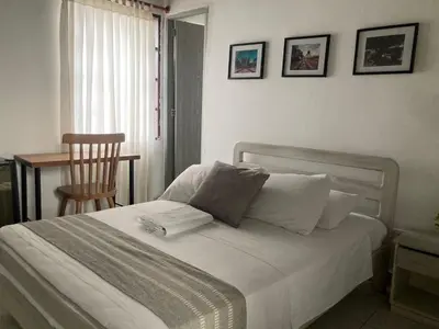 a bedroom with a bed with a chair and a table at Hotel Casa de las Dos Palmas -Hotel Boutique in Puerto Berrío