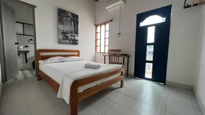 a bedroom with a bed and a window and a door at Hotel Casa de las Dos Palmas -Hotel Boutique in Puerto Berrío