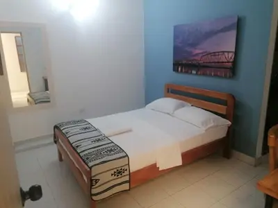 a bedroom with a bed with a painting on the wall at Hotel Casa de las Dos Palmas -Hotel Boutique in Puerto Berrío